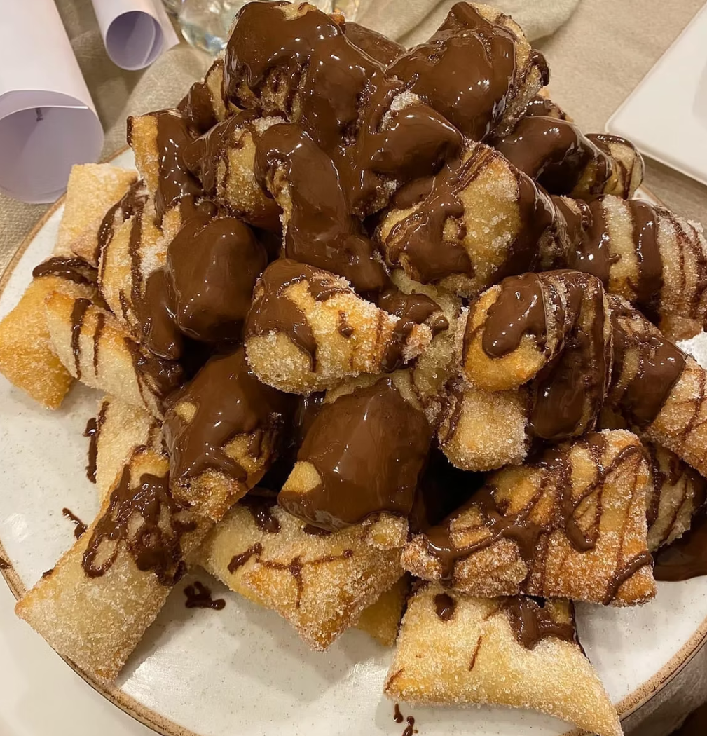 Pyramid of golden pastries drizzled with rich chocolate