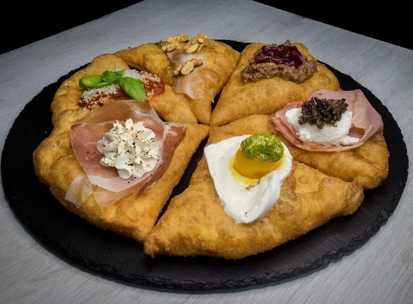 Six artisanal montanare varieties on black slate — the signature of Chef Othman's Italian craft