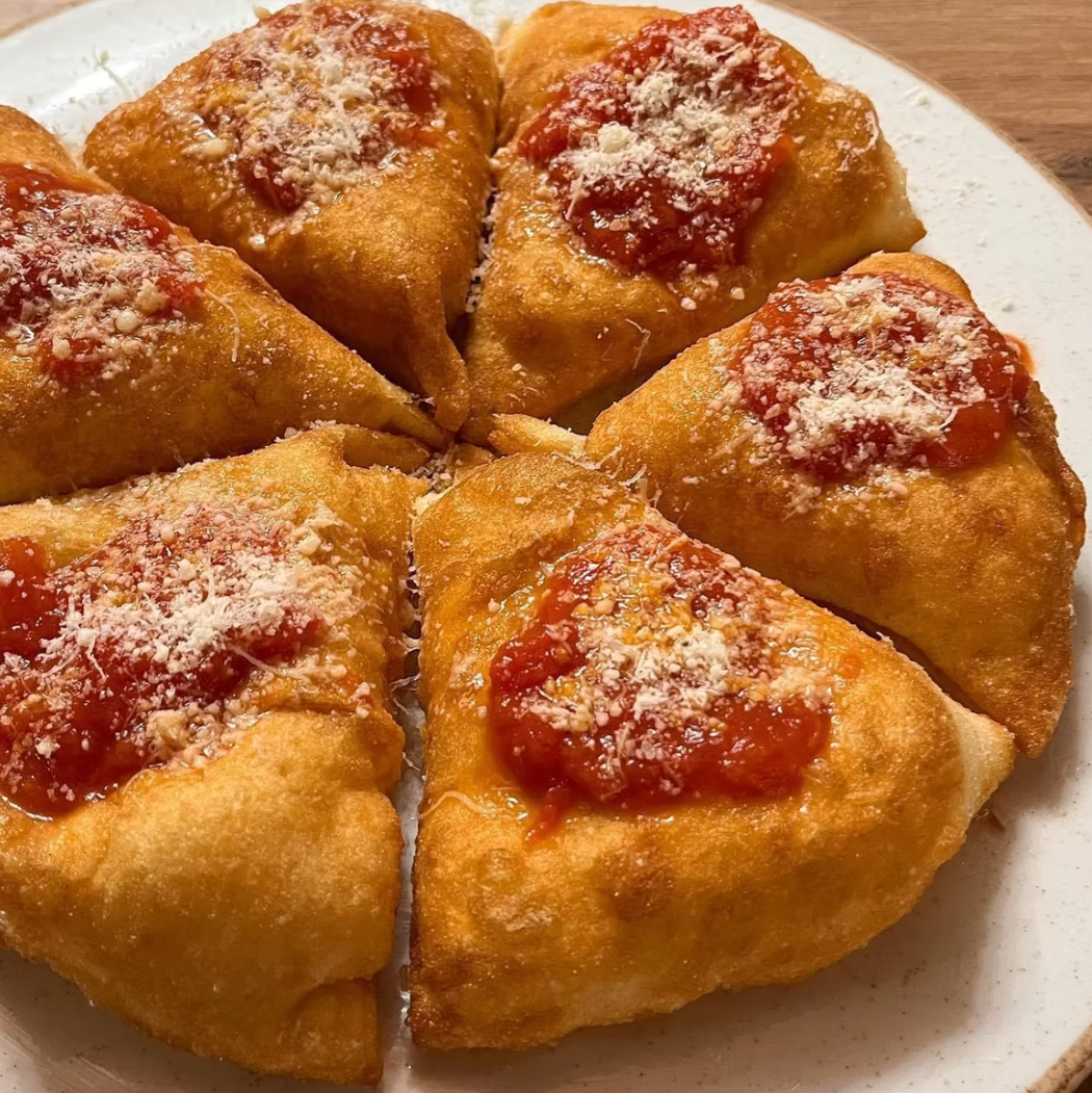 Golden montanare topped with San Marzano tomato sauce and Parmigiano
